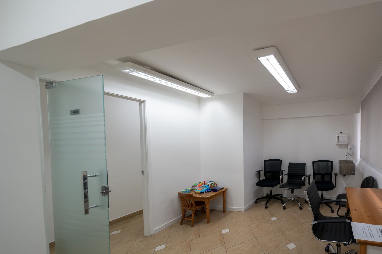 Sala ampla com porta de vidro, cantinho infantil e cadeiras