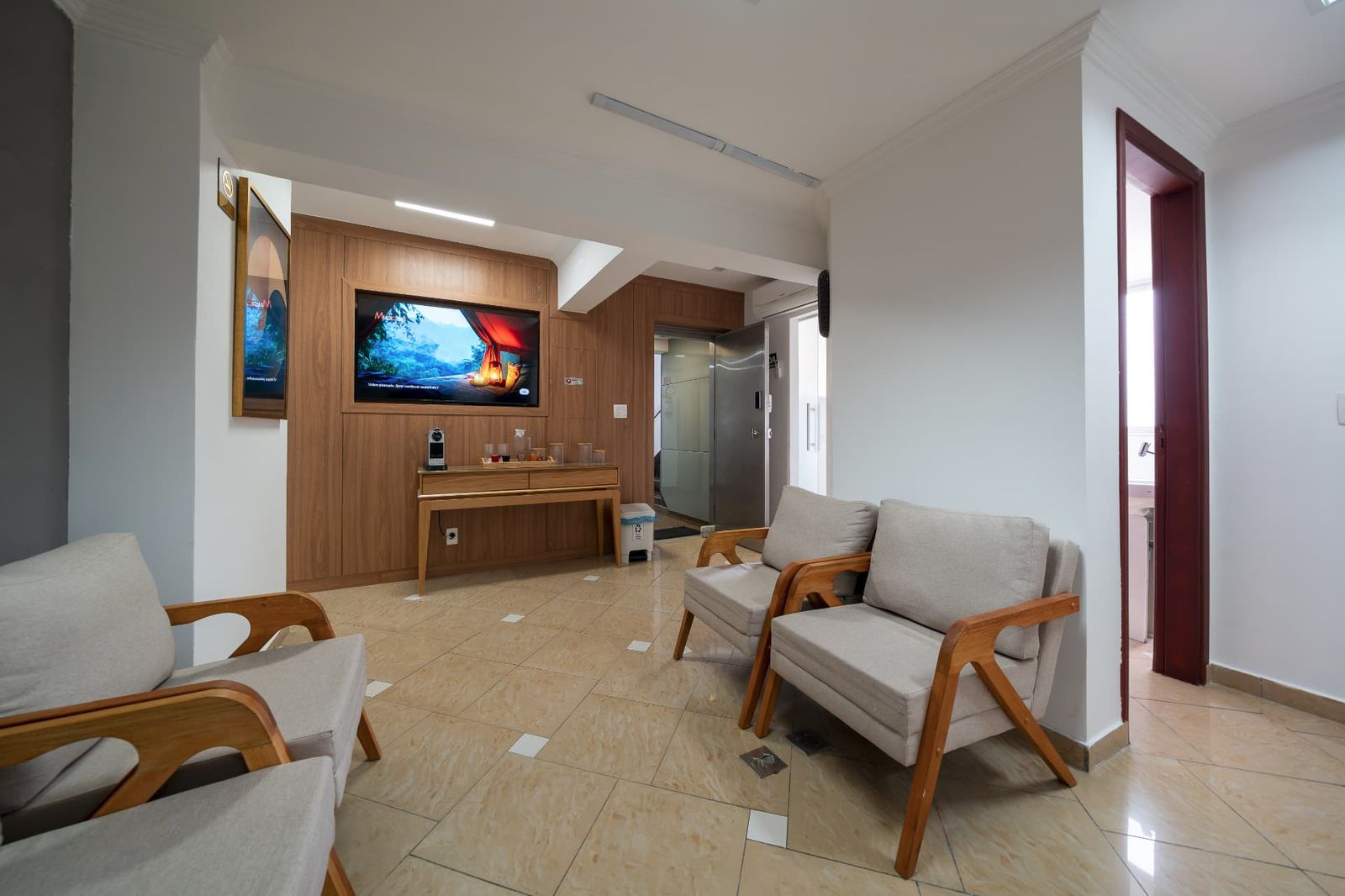 Espera com TV, painel de madeira e máquina de café